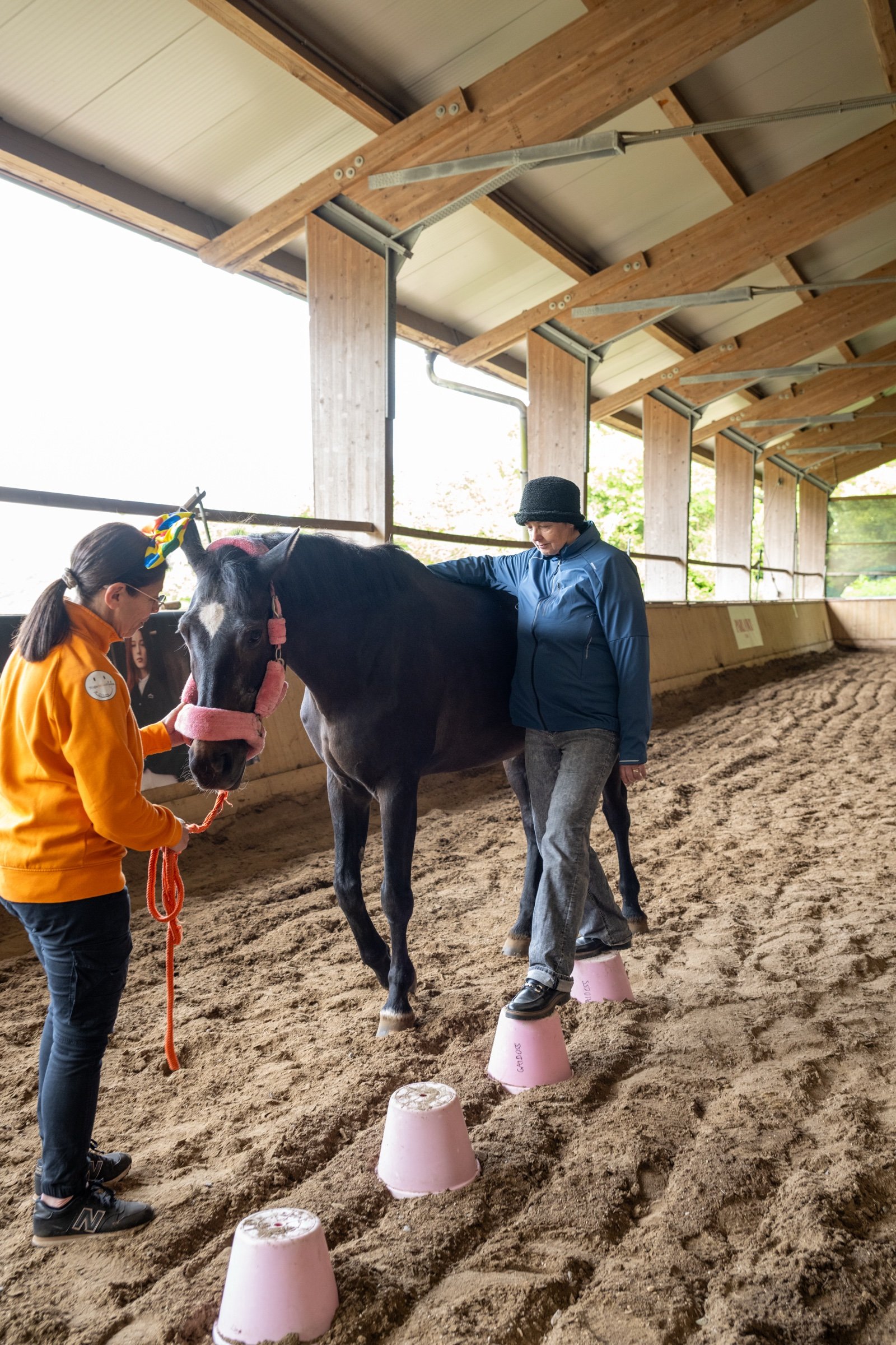 Una partecipante accanto a un cavallo durante un esercizio di gruppo