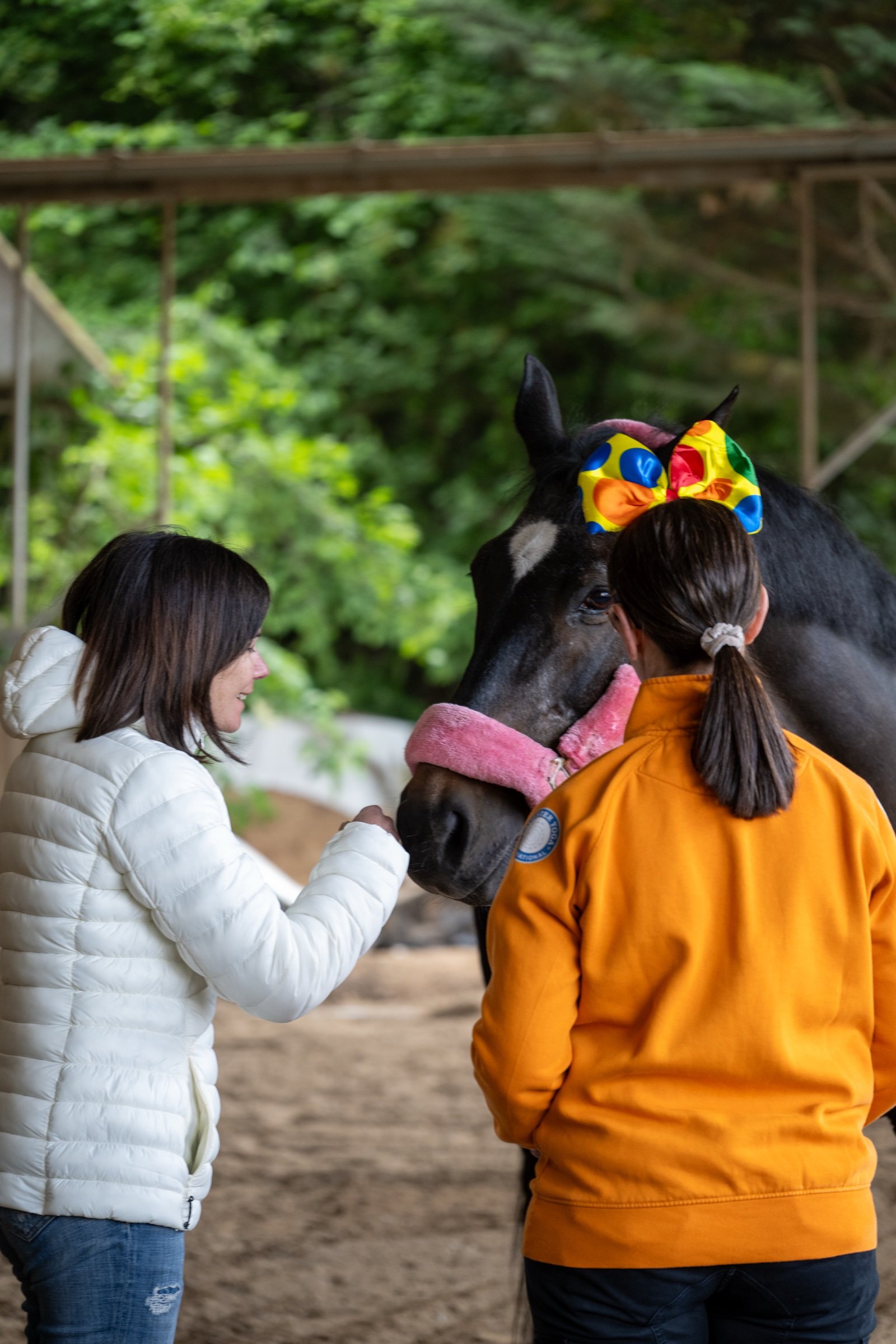 Monia Carnevali e una partecipante vicino al muso di un cavallo