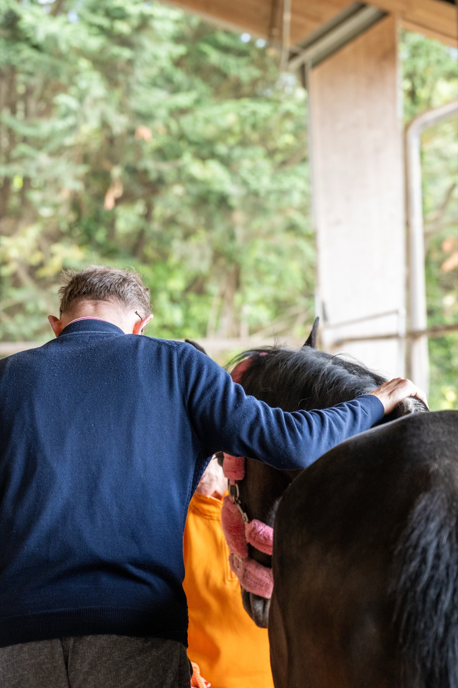 Un uomo cammina a testa bassa accanto a un cavallo